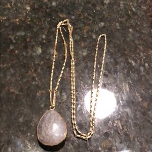 Gold necklace with grey stone.